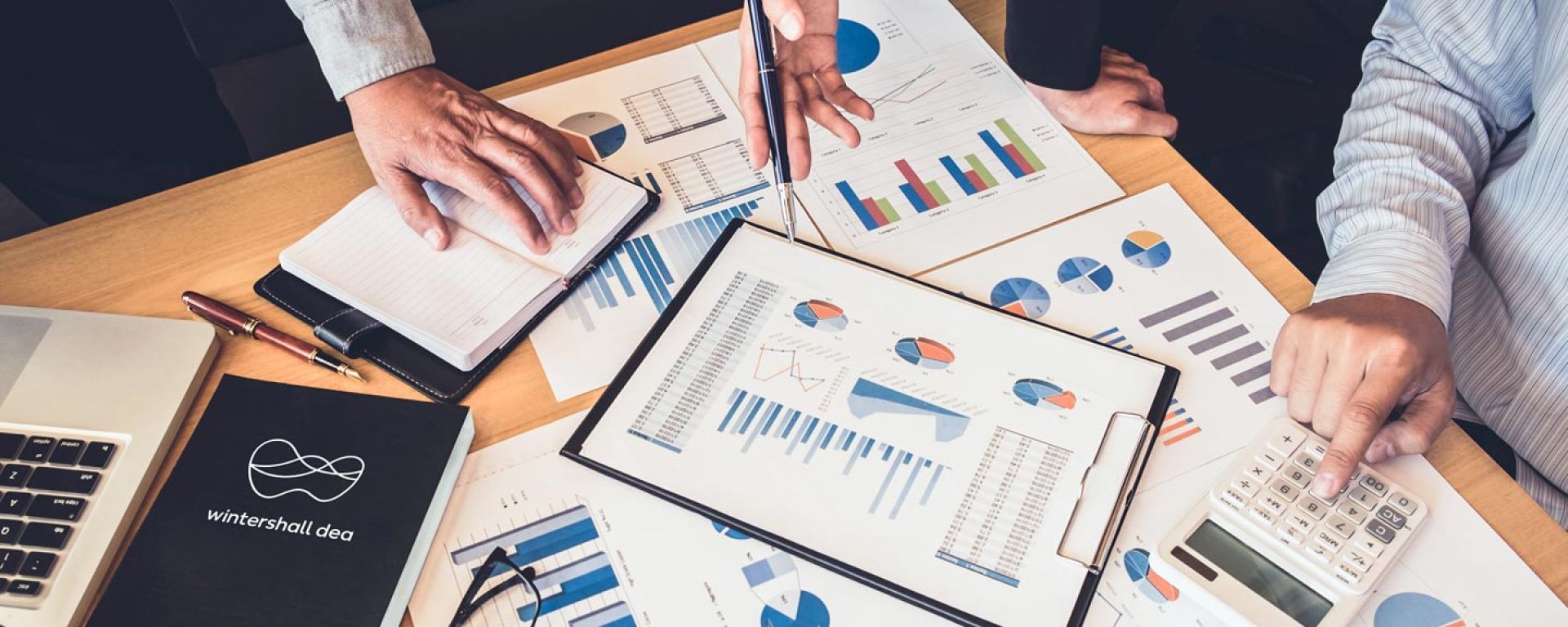 Documents, tables and diagrams on the subject of Wintershall Dea's investor relations on a desk